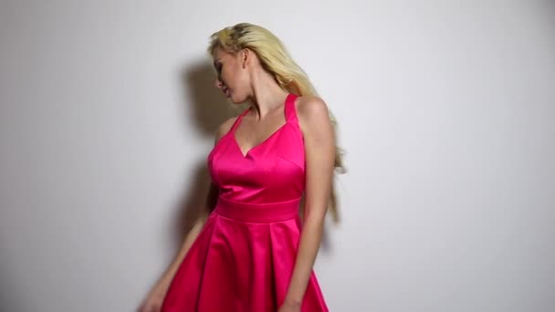 Vacker sexig kvinna i rosa klänning posera mot studio bakgrund. Slow Motion Footage. — Stockvideo
