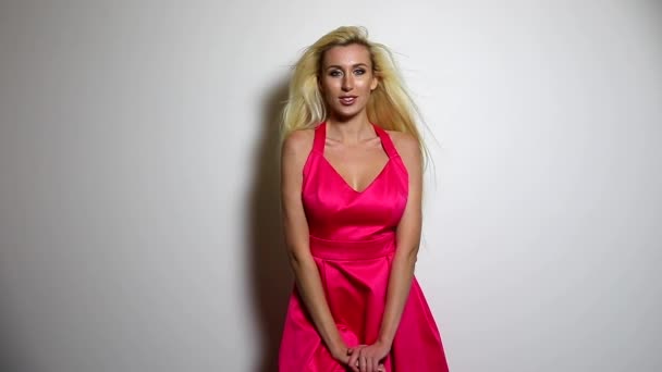 Όμορφη σέξι γυναίκα σε ροζ φόρεμα θέτουν studio φόντο. Αργή κίνηση μήκος σε πόδηα. — Αρχείο Βίντεο