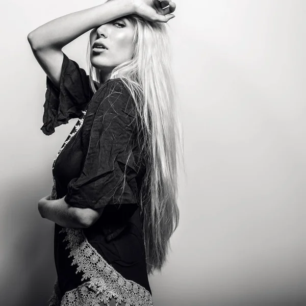 Schöne sexy blonde Frau posiert vor Studiohintergrund. Schwarz-Weiß-Foto. — Stockfoto