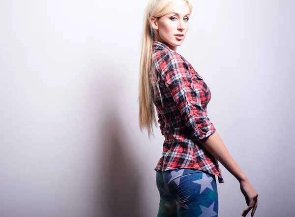 Vacker sexig blond kvinna utgör mot studio bakgrund. — Stockfoto