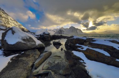 Akşam zaman soğuk Norveç Denizi kıyısında antik taşlar. Lofoten Adaları. Güzel Norveç manzara.