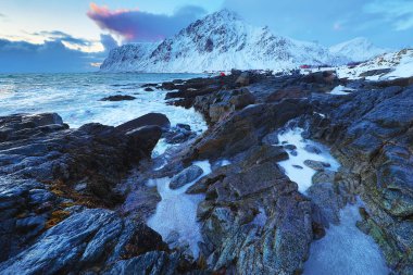 Akşam zaman soğuk Norveç Denizi kıyısında antik taşlar. Lofoten Adaları. Güzel Norveç manzara.
