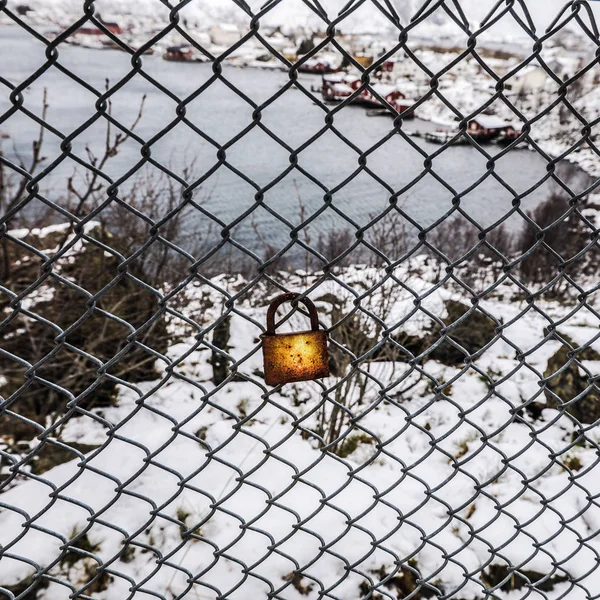 Rusted lock on the grid against snow background. — Stock Photo, Image