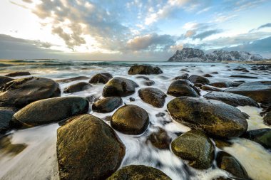 Akşam zaman soğuk Norveç Denizi kıyısında antik taşlar. Lofoten Adaları. Güzel Norveç manzara.