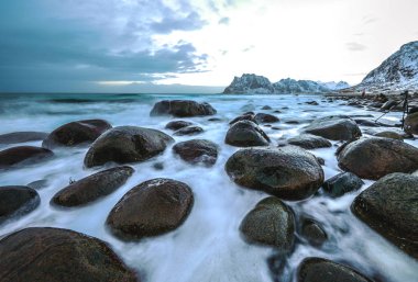 Akşam zaman soğuk Norveç Denizi kıyısında antik taşlar. Lofoten Adaları. Güzel Norveç manzara.