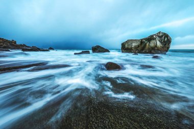 Akşam zaman soğuk Norveç Denizi kıyısında antik taşlar. Lofoten Adaları. Güzel Norveç manzara.