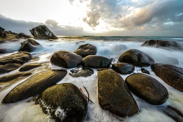 Antiguas piedras en las orillas del frío Mar de Noruega a la hora de la tarde. Islas Lofoten. Hermoso paisaje de Noruega . — Foto de Stock