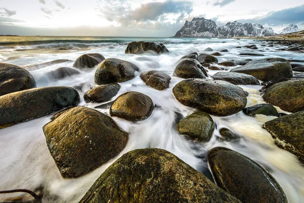 夜の時間に冷たいノルウェー海のほとりに古代の石。ロフォーテン諸島。美しいノルウェーの風景. — ストック写真