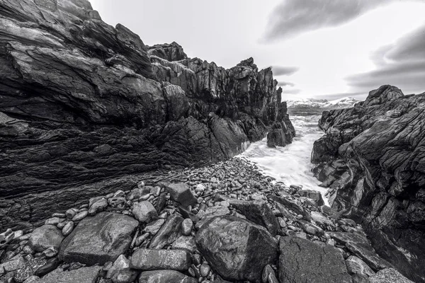 Pedras antigas nas margens do frio Mar da Noruega à noite. Ilhas Lofoten. Bela paisagem norueguesa. Foto preto-branco . — Fotografia de Stock