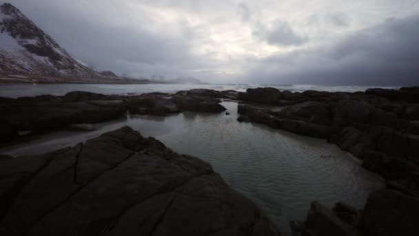 夜の時間に冷たいノルウェー海のほとりに古代の石。ロフォーテン諸島。美しいノルウェーの風景です。Hd 映像. — ストック動画