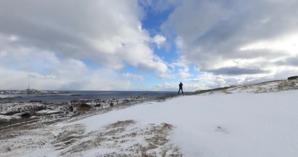 एक धूप के दिन और प्रकृति वॉकर पर शानदार बर्फ से ढकी हुई चट्टानों। लोगों के साथ सुंदर नॉर्वे परिदृश्य। लोफोटन द्वीपों . — स्टॉक वीडियो