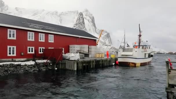 ロフォーテン諸島の伝統的な漁業集落の古い桟橋で釣り船。美しいノルウェーの風景です。Hd 映像. — ストック動画