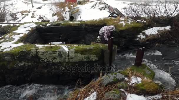 Девушка пьет чистую воду из горного ручья . — стоковое видео