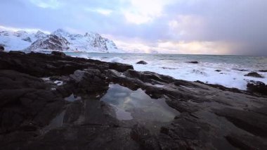 Akşam zaman soğuk Norveç Denizi kıyısında su hareketi. Lofoten Adaları. Güzel Norveç manzara. HD ayak. 