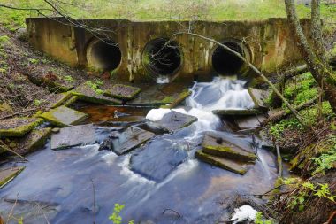 Nehir baraj boru içinde akan su ile bir orman yolu köprü altında yapılan.