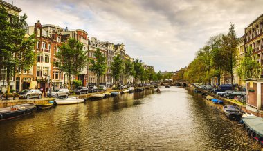 En ünlü kanallar ve bentleri Amsterdam City günbatımı sırasında. Cityscape ve geleneksel Hollanda mimarisinin genel görünümü.