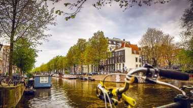 En ünlü kanallar ve bentleri Amsterdam City günbatımı sırasında. Cityscape ve geleneksel Hollanda mimarisinin genel görünümü.