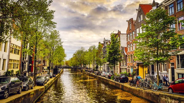 Die berühmtesten kanäle und dämme der stadt amsterdam bei untergang. Überblick über das Stadtbild und die traditionelle niederländische Architektur. — Stockfoto