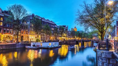 En ünlü kanallar ve bentleri Amsterdam City günbatımı sırasında. Cityscape ve geleneksel Hollanda mimarisinin genel görünümü.