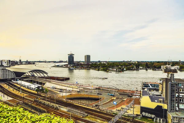 De meest beroemde grachten en ophogingen van Amsterdam tijdens zonsondergang. Algemeen beeld van het stadslandschap en de traditionele architectuur van Nederland. — Stockfoto