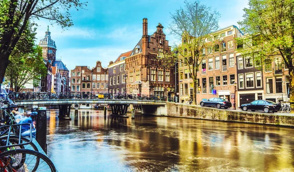 Os canais e aterros mais famosos da cidade de Amsterdã durante o pôr do sol. Vista geral da paisagem urbana e da arquitectura tradicional neerlandesa . — Fotografia de Stock