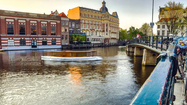 De mest berømte kanaler og dæmninger i Amsterdam by under solnedgang. Generel oversigt over bybilledet og den traditionelle nederlandske arkitektur . - Stock-foto