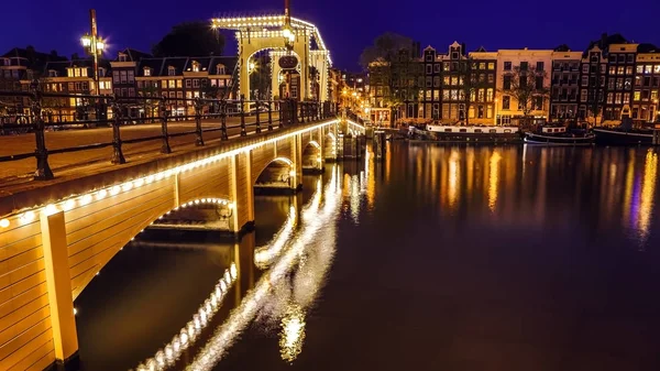 Puentes y terraplenes de Ámsterdam al anochecer. Vista general del paisaje urbano y la arquitectura tradicional holandesa . — Foto de Stock