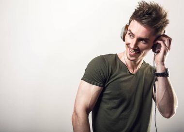 Yeşil t-shirt gri studio arka plan müzik dinleme dostu sportif erkekte yakışıklı.