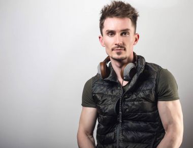 Yeşil t-shirt gri studio arka plan müzik dinleme dostu sportif erkekte yakışıklı.