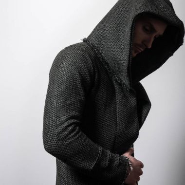 Yakışıklı sportif delikanlı koyu yeşil kapşonlu gri studio arka planı poz.