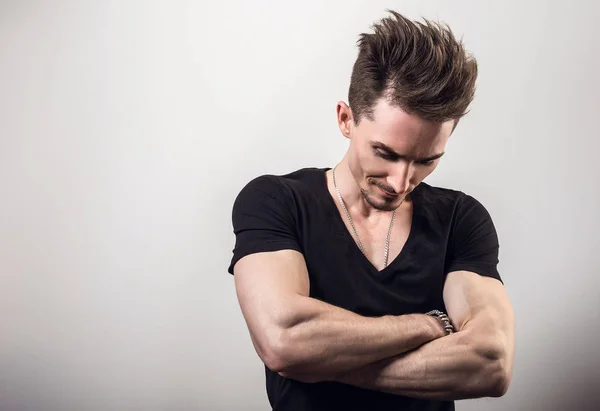 Handsome young sporty man in black t-shirt pose against gray studio background. — Stock Photo, Image