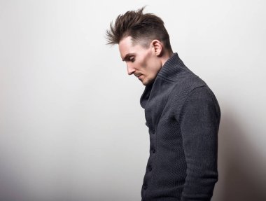 Yakışıklı zarif delikanlı gri switer poz studio arka planı.