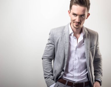 Zarif yakışıklı genç gri ceketli poz studio arka planı.