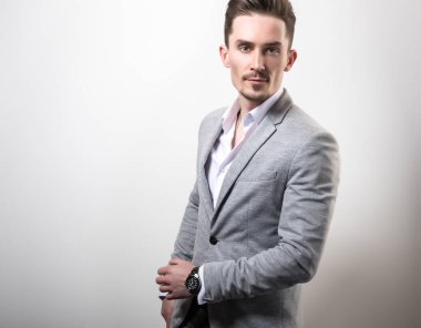 Zarif yakışıklı genç gri ceketli poz studio arka planı.