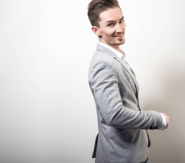 Zarif yakışıklı genç gri ceketli poz studio arka planı.