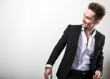 Zarif yakışıklı genç siyah şık klasik kostüm poz studio arka planı.