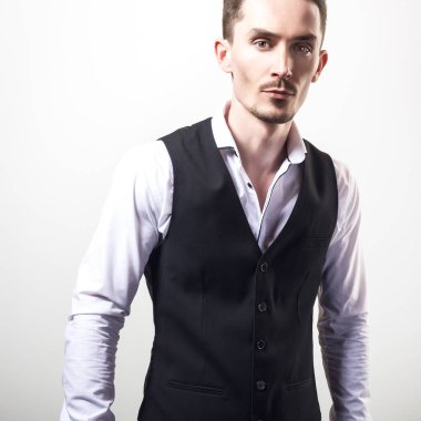 Yakışıklı zarif delikanlı siyah klasik yelek poz studio arka planı.