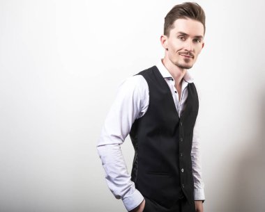 Yakışıklı zarif delikanlı siyah klasik yelek poz studio arka planı.