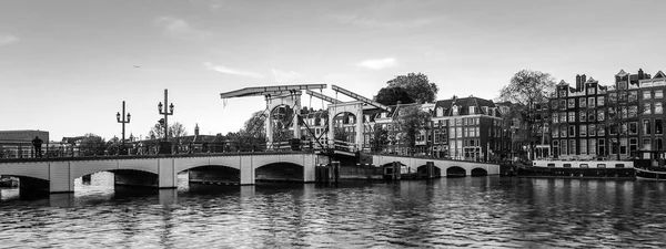 Brücken und Dämme von Amsterdam in der Dämmerung. Überblick über das Stadtbild und die traditionelle niederländische Architektur. — Stockfoto