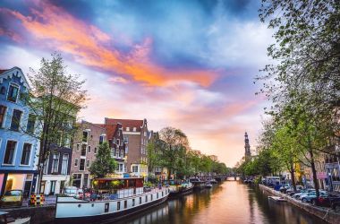 En ünlü kanallar ve bentleri Amsterdam City günbatımı sırasında. Cityscape ve geleneksel Hollanda mimarisinin genel görünümü.
