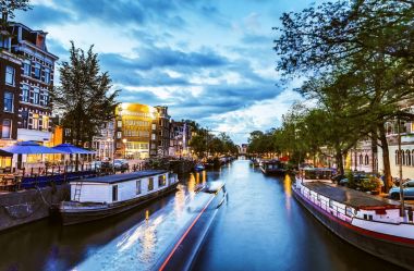 En ünlü kanallar ve gece Amsterdam şehir bentleri. Cityscape ve geleneksel Hollanda mimarisinin genel görünümü.