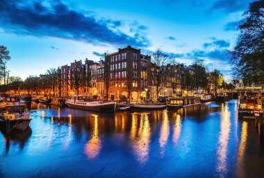 En ünlü kanallar ve gece Amsterdam şehir bentleri. Cityscape ve geleneksel Hollanda mimarisinin genel görünümü.
