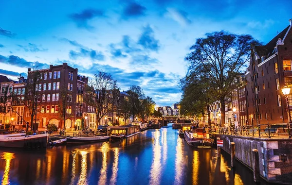 En ünlü kanallar ve gece Amsterdam şehir bentleri. Cityscape ve geleneksel Hollanda mimarisinin genel görünümü.