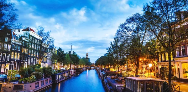 Los canales y terraplenes más famosos de la ciudad de Ámsterdam por la noche. Vista general del paisaje urbano y la arquitectura tradicional holandesa . — Foto de Stock