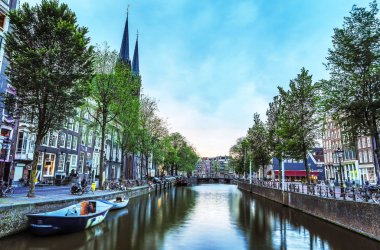 En ünlü kanallar ve bentleri Amsterdam City günbatımı sırasında. Cityscape ve geleneksel Hollanda mimarisinin genel görünümü.