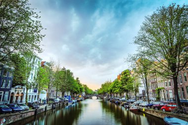 En ünlü kanallar ve bentleri Amsterdam City günbatımı sırasında. Cityscape ve geleneksel Hollanda mimarisinin genel görünümü.