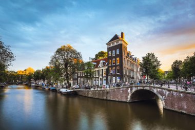 En ünlü kanallar ve bentleri Amsterdam City günbatımı sırasında. Cityscape ve geleneksel Hollanda mimarisinin genel görünümü.