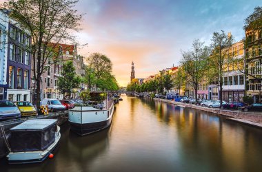 En ünlü kanallar ve bentleri Amsterdam City günbatımı sırasında. Cityscape ve geleneksel Hollanda mimarisinin genel görünümü.