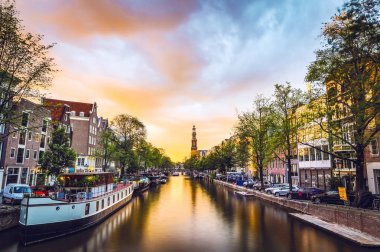 En ünlü kanallar ve bentleri Amsterdam City günbatımı sırasında. Cityscape ve geleneksel Hollanda mimarisinin genel görünümü.