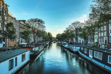 En ünlü kanallar ve bentleri Amsterdam City günbatımı sırasında. Cityscape ve geleneksel Hollanda mimarisinin genel görünümü.